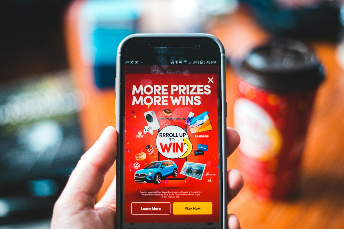 Hand holding a smartphone displaying a promotional prize advertisement.