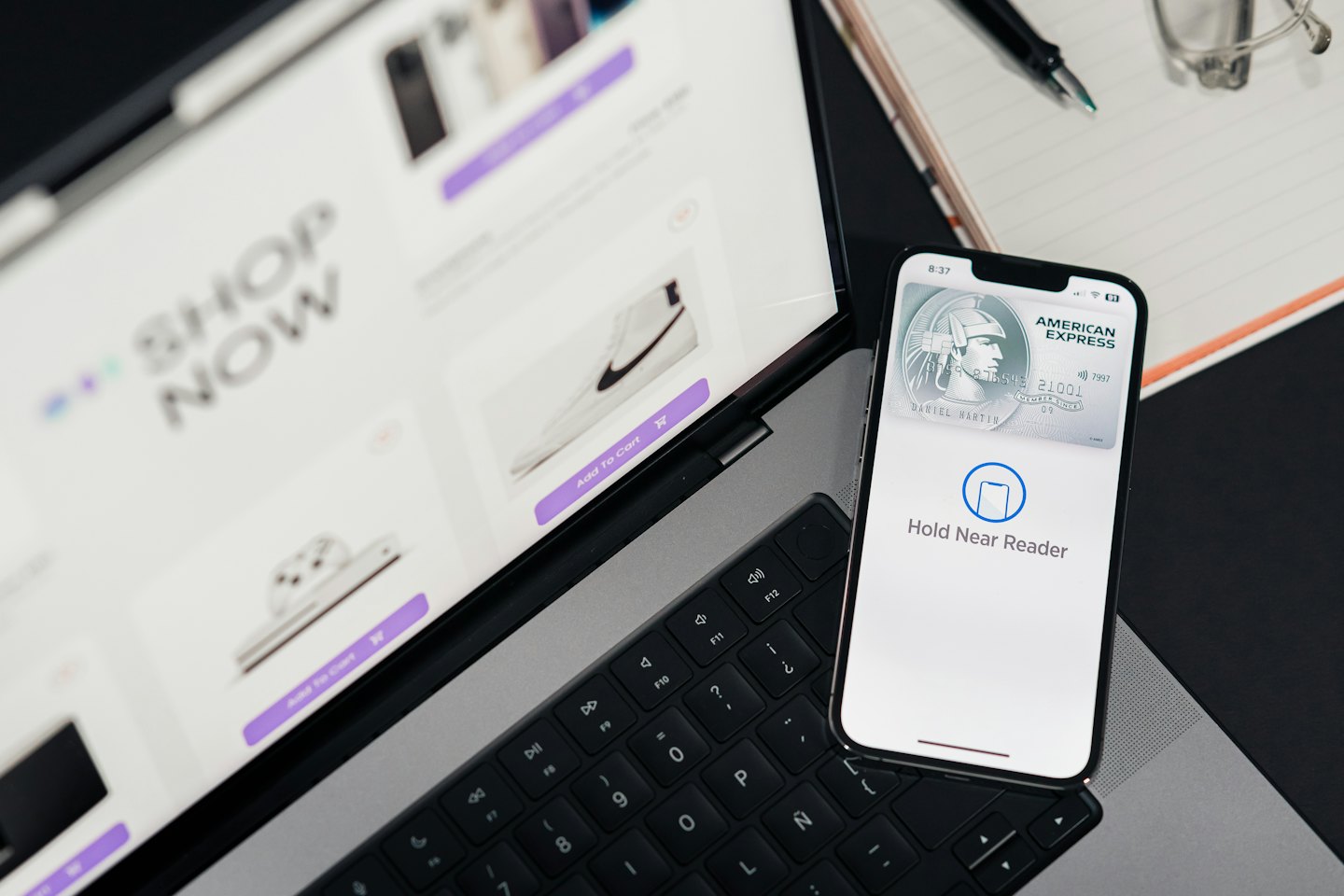 Laptop and smartphone facilitate online shopping and payment.